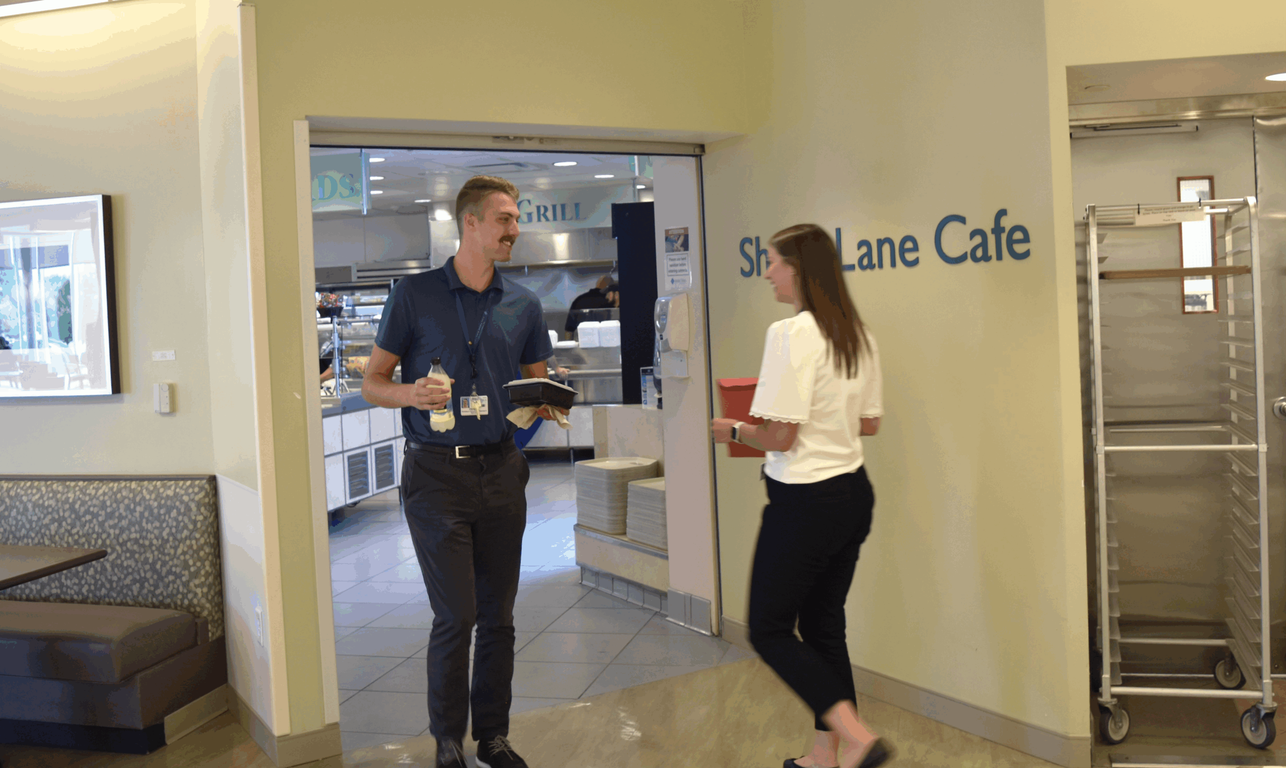 Two hospital employees chatting near the entrance of Shady Lane Cafe