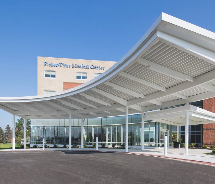 Fisher-Titus Medical Center exterior entrance with a curved white canopy and glass facade