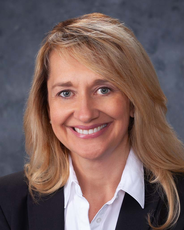 Professional headshot of a woman with blonde hair in a dark blazer and white shirt