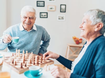 Seniors laughing while playing chess