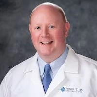 Smiling male physician in a white Fisher-Titus lab coat and blue tie