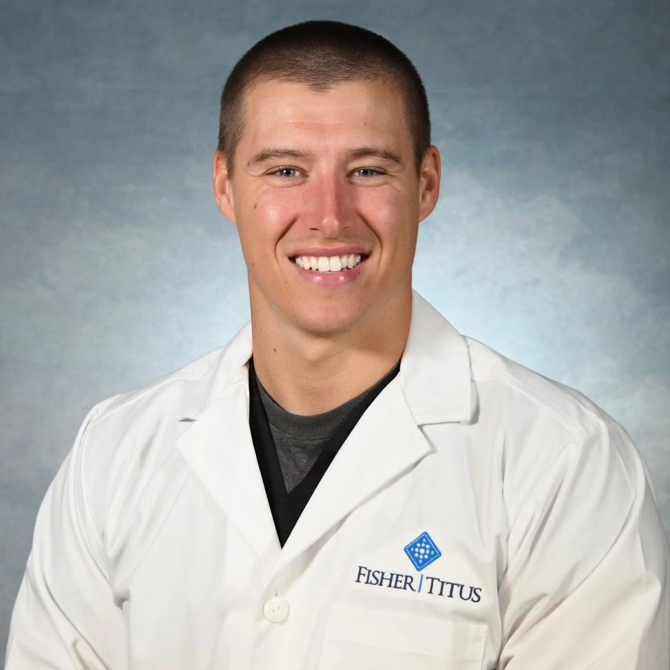 Fisher-Titus male provider in white lab coat smiling for professional headshot