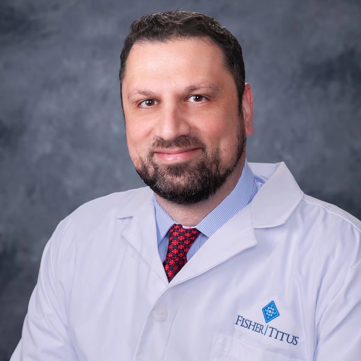 Smiling male provider in a white Fisher-Titus coat and red tie